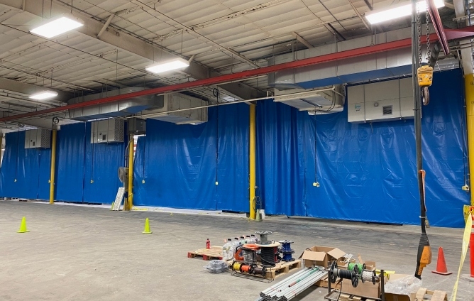 warehouse with parts and a blue tarp